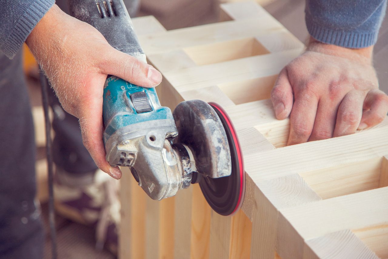 Mastering the First Impression: Your intriguing post title goes here Crop unrecognizable male carpenter using angle grinder to polish wooden construction in light joinery